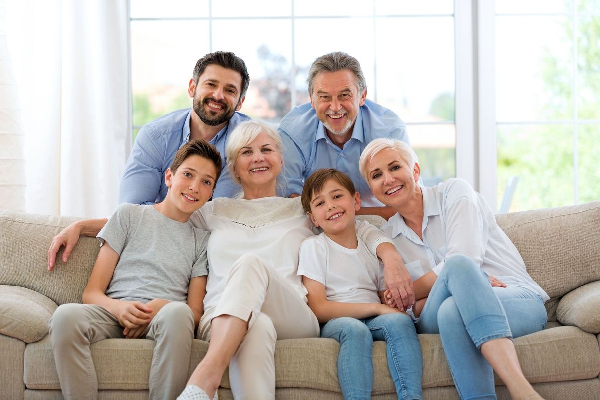 Eine Familie, die in einem hellen Raum auf einer Couch zusammensitzt